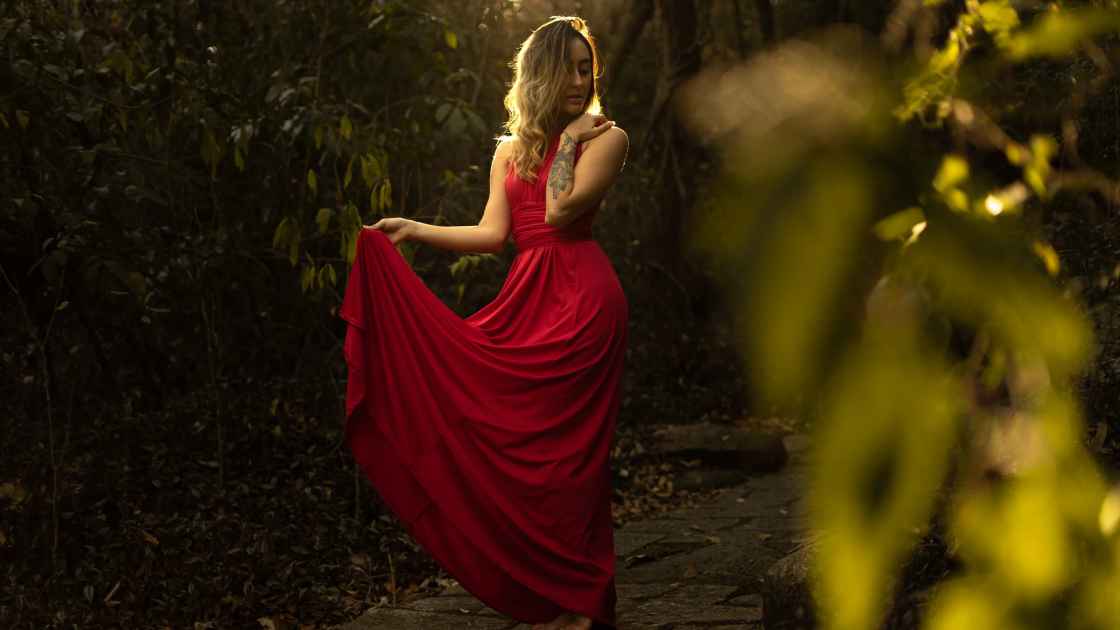 catchy-red-dress-captions-for-Instagram-beautiful-girl-standing-in-red-dress-in-forest-spadequotes