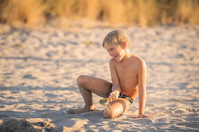 pngtree cheerful youngster enjoying playful moments with sand at the seaside photo image 48691462